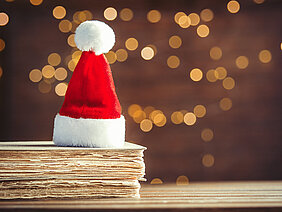 Santa Claus Christmas hat and old books